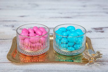 Colorful and chocolate covered almond candies in pastel tones in crystal sugar bowl. Traditional Turkish colorful coated almond candies.Colorful candies background top view, almond sweets.