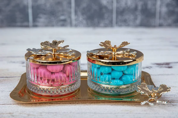 Colorful and chocolate covered almond candies in pastel tones in crystal sugar bowl. Traditional Turkish colorful coated almond candies.Colorful candies background top view, almond sweets.
