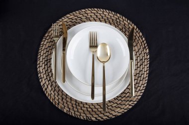 Plates and utensils, Plate, Bowl and golden cutlery against dining table background, side view. Modern craft ceramic tableware.