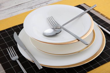 Silver cutlery, porcelain plate, restaurant menu concept. Table set on dining table with and white plate setting.