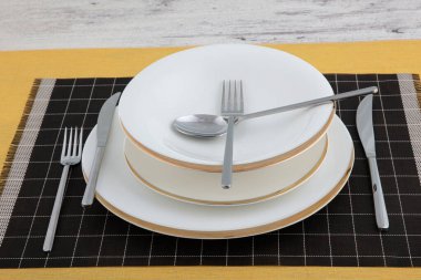 Silver cutlery, porcelain plate, restaurant menu concept. Table set on dining table with and white plate setting.