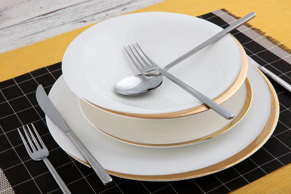 Silver cutlery, porcelain plate, restaurant menu concept. Table set on dining table with and white plate setting.