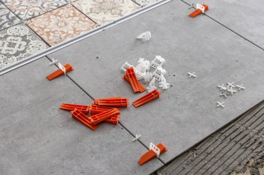 industrial ceramic builder worker installing floor tile at repair renovation work - Handyman installing ceramic tiles - A special cement mass to fill gaps between the laid ceramics.