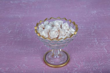 Kristal bir tabakta Türk lokumu, Türk lokumu. Pembe ahşap arka plan. Durgun yaşam, yiyecek ve içecek, mevsimlik ve tatil (ramazan, şeker bayramı) kavramı.