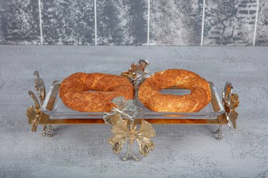 Simit ya da gevrek, ahşap arka planda geleneksel Türk hamur yemeği. Türk sokak yemekleri dairesel ekmek, susamlı simit. Türk simitleri veya maymunu veya yaşamları veya koulouri.