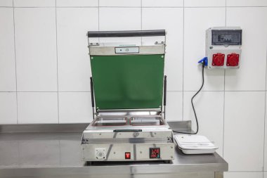 Depoda içi boş metal raflarla dolu soğuk bir oda. Soğuk odadaki çelik rafta yiyecek paketleme makinesi. Fabrikada, dükkanda ya da restoranda buzdolabı kompartımanı