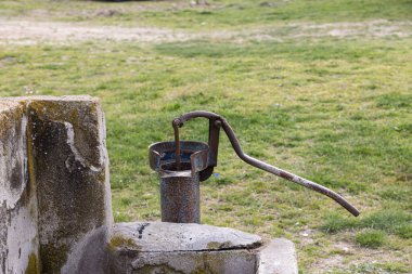 Türkiye 'deki tarladan su çekmek için kullanılan eski pompa. Retro iyi pompa, eski manuel su pompası (kaldıraç). Klasik dökme demir su pompası. 4K video çekimi.