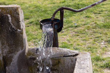 Türkiye 'deki tarladan su çekmek için kullanılan eski pompa. Retro iyi pompa, eski manuel su pompası (kaldıraç). Klasik dökme demir su pompası. 4K video çekimi.