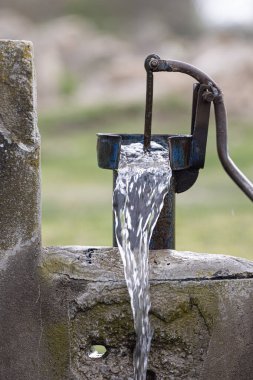 Türkiye 'deki tarladan su çekmek için kullanılan eski pompa. Retro iyi pompa, eski manuel su pompası (kaldıraç). Klasik dökme demir su pompası. 4K video çekimi.