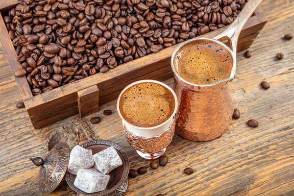 木製のテーブルの上に散在銅カップとローストコーヒー豆で黒トルココーヒー 銅カップとトルコの喜び ホットドリンクの概念で伝統的なトルコのコーヒー — ストック写真