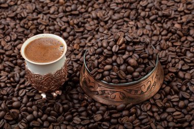 Türk kahvesi konsepti, kahve çekirdekli kahve fonu. Bakır bardakta Türk kahvesi.