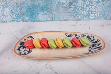 Renkli kurabiyeler. Küçük Fransız çörekleri. Tatlı ve renkli Fransız badem kurabiyeleri. Gri mermer arka planda renkli badem kurabiyeleri. Üst Manzara. pastel renkler.