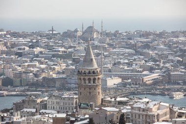 İstanbul, Türkiye 'deki Galata Kulesi. Altın saat havası ve güzel güneş ışığı manzarası. İstanbul Süleyman Camii ve Galata Kulesi 'nde kar ve kış mevsimi manzarası.