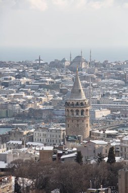 İstanbul, Türkiye 'deki Galata Kulesi. Altın saat havası ve güzel güneş ışığı manzarası. İstanbul Süleyman Camii ve Galata Kulesi 'nde kar ve kış mevsimi manzarası.