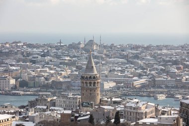 İstanbul, Türkiye 'deki Galata Kulesi. Altın saat havası ve güzel güneş ışığı manzarası. İstanbul Süleyman Camii ve Galata Kulesi 'nde kar ve kış mevsimi manzarası.