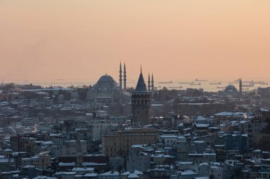 İstanbul, Türkiye 'deki Galata Kulesi. Altın saat havası ve güzel güneş ışığı manzarası. İstanbul Süleyman Camii ve Galata Kulesi 'nde kar ve kış mevsimi manzarası.