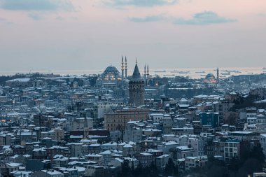 İstanbul, Türkiye 'deki Galata Kulesi. Altın saat havası ve güzel güneş ışığı manzarası. İstanbul Süleyman Camii ve Galata Kulesi 'nde kar ve kış mevsimi manzarası.