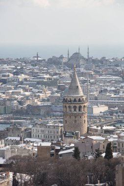 İstanbul, Türkiye 'deki Galata Kulesi. Altın saat havası ve güzel güneş ışığı manzarası. İstanbul Süleyman Camii ve Galata Kulesi 'nde kar ve kış mevsimi manzarası.