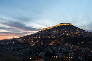 Mardin şehri, Türkiye. Taş evleri ve tarihi dokusunun yanı sıra Mardin, gece görüşüyle turistleri etkiliyor. Uzun pozlu yüksek kaliteli fotoğraf.