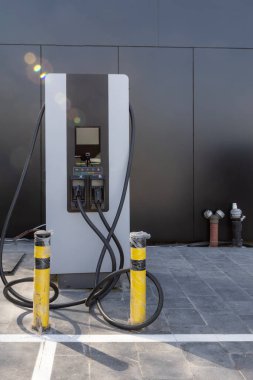 EV elektrikli arabayı şarj ediyor. Elektrikli araba şarjı için güç kaynağı. Elektrikli araba aküsü için priz. Otoparktaki EV araba şarj istasyonu. Doğa enerjisi, Temiz enerji, Yeşil eko konsepti.