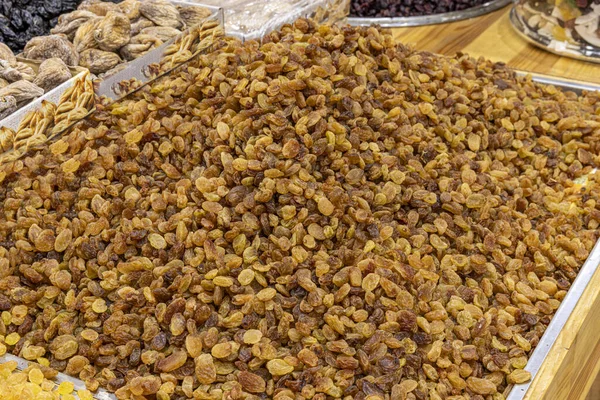 stock image Raisins are heaped on the counter of a store or in the market. Dried fruits. Golden dried grapes without seeds on the market counter. 