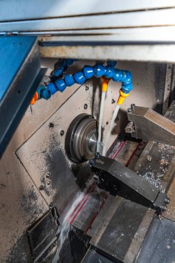 Metal işleme işlemi. Dikey değirmenle çalışan endüstriyel CNC metali. Metal endüstrisi: atölyedeki torna makinesinin çelik şaft işlemesini kesmek. Araç üzerine seçmeli odak.