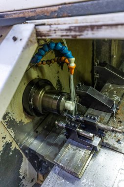 Metal işleme işlemi. Dikey değirmenle çalışan endüstriyel CNC metali. Metal endüstrisi: atölyedeki torna makinesinin çelik şaft işlemesini kesmek. Araç üzerine seçmeli odak.