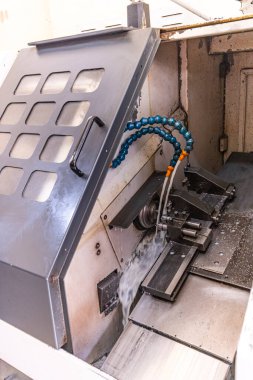 Metal işleme işlemi. Dikey değirmenle çalışan endüstriyel CNC metali. Metal endüstrisi: atölyedeki torna makinesinin çelik şaft işlemesini kesmek. Araç üzerine seçmeli odak.