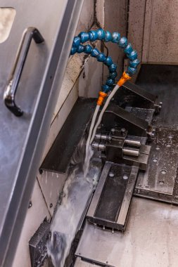 Metal işleme işlemi. Dikey değirmenle çalışan endüstriyel CNC metali. Metal endüstrisi: atölyedeki torna makinesinin çelik şaft işlemesini kesmek. Araç üzerine seçmeli odak.