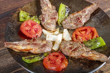 Kuzu pirzola ızgara kuzu pirzolası. Kreatif restoran zemininde kızarmış pirzola. Baharatlı ve soslu kuzu kaburgası.