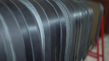 Deri kemer fabrikası. Özel deri el sanatları atölyesindeki dikiş makinesinde çalışan terzinin yakın çekim görüntüsü, dikiş kemeri işleniyor. Erkek terzi 4K video 'da deri atölyede deri kemer dikiyor..