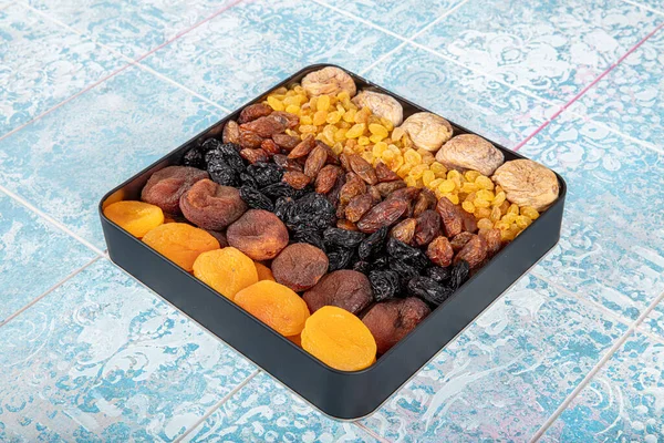 Mixed dried fruits box. Dried fruit background. Rows of dried dates, apricots, raisins, hazelnuts, dried apricots and figs.
