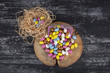Koyu arkaplanda izole edilmiş çikolata içinde şekerli badem ve fındıklı bira yığını. Fındık dolu el yapımı renkli çikolata şekerleri. Çikolata şekerlemeleri ve Çakıl Taşı çikolataları..