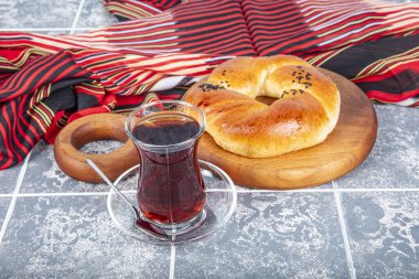 Türk hamur işi ürünü. Esmer arka planda hamur işi. Yerel adı Sade Pogaca. Geleneksel Türk hamur işi acma ve çay kırsal masada, ünlü fırın ürünü.