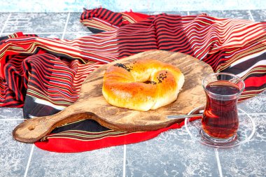 Türk hamur işi ürünü. Esmer arka planda hamur işi. Yerel adı Sade Pogaca. Geleneksel Türk hamur işi acma ve çay kırsal masada, ünlü fırın ürünü.