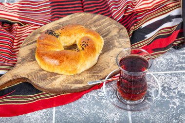 Türk hamur işi ürünü. Esmer arka planda hamur işi. Yerel adı Sade Pogaca. Geleneksel Türk hamur işi acma ve çay kırsal masada, ünlü fırın ürünü.