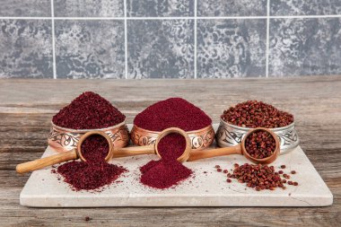 Tahta kaşıkta kuru baharatlı sumak. Yer sumac baharatı. Kurutulmuş kırmızı Sumac tozu, ahşap kaşıkta, kırsal masada sumak üzümlü baharatlar. Sağlıklı gıda konsepti.