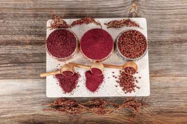 Tahta kaşıkta kuru baharatlı sumak. Yer sumac baharatı. Kurutulmuş kırmızı Sumac tozu, ahşap kaşıkta, kırsal masada sumak üzümlü baharatlar. Sağlıklı gıda konsepti.