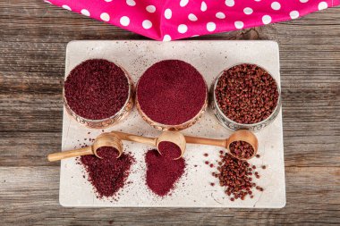 Tahta kaşıkta kuru baharatlı sumak. Yer sumac baharatı. Kurutulmuş kırmızı Sumac tozu, ahşap kaşıkta, kırsal masada sumak üzümlü baharatlar. Sağlıklı gıda konsepti.