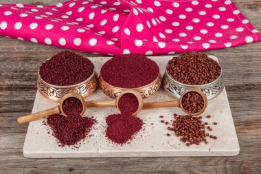 Tahta kaşıkta kuru baharatlı sumak. Yer sumac baharatı. Kurutulmuş kırmızı Sumac tozu, ahşap kaşıkta, kırsal masada sumak üzümlü baharatlar. Sağlıklı gıda konsepti.