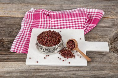 Tahta kaşıkta kuru baharatlı sumak. Yer sumac baharatı. Kurutulmuş kırmızı Sumac tozu, ahşap kaşıkta, kırsal masada sumak üzümlü baharatlar. Sağlıklı gıda konsepti.