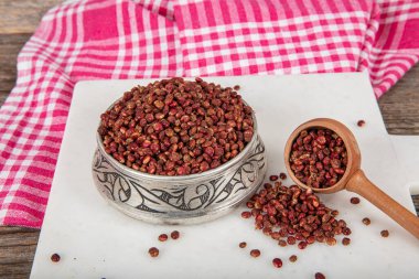 Tahta kaşıkta kuru baharatlı sumak. Yer sumac baharatı. Kurutulmuş kırmızı Sumac tozu, ahşap kaşıkta, kırsal masada sumak üzümlü baharatlar. Sağlıklı gıda konsepti.