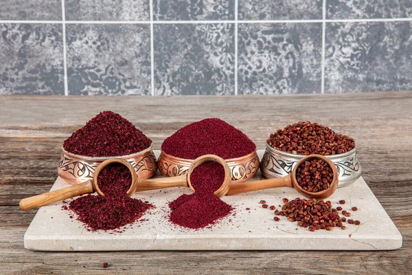Tahta kaşıkta kuru baharatlı sumak. Yer sumac baharatı. Kurutulmuş kırmızı Sumac tozu, ahşap kaşıkta, kırsal masada sumak üzümlü baharatlar. Sağlıklı gıda konsepti.