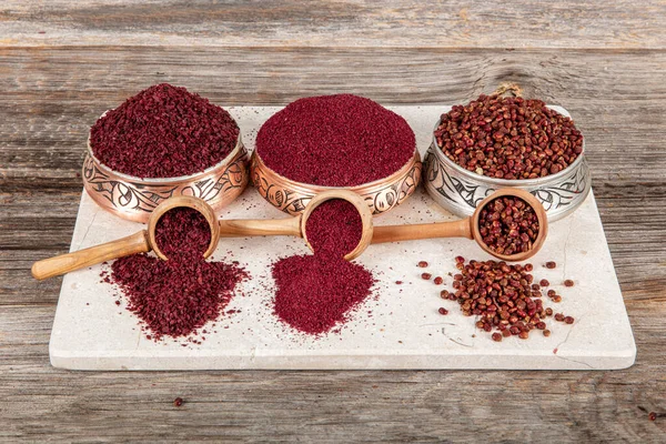 Tahta kaşıkta kuru baharatlı sumak. Yer sumac baharatı. Kurutulmuş kırmızı Sumac tozu, ahşap kaşıkta, kırsal masada sumak üzümlü baharatlar. Sağlıklı gıda konsepti.