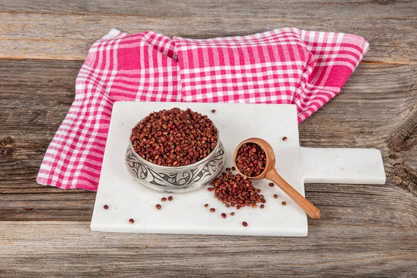 Tahta kaşıkta kuru baharatlı sumak. Yer sumac baharatı. Kurutulmuş kırmızı Sumac tozu, ahşap kaşıkta, kırsal masada sumak üzümlü baharatlar. Sağlıklı gıda konsepti.