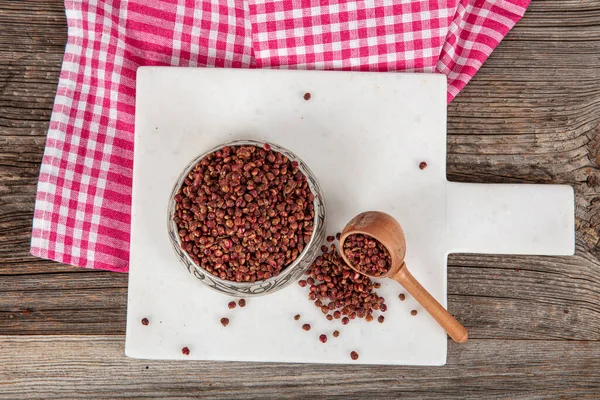 Tahta kaşıkta kuru baharatlı sumak. Yer sumac baharatı. Kurutulmuş kırmızı Sumac tozu, ahşap kaşıkta, kırsal masada sumak üzümlü baharatlar. Sağlıklı gıda konsepti.