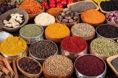 Kase içinde pişirmek için çeşitli otlar ve baharatlar içeren renkli bir arka plan. Baharat ve bitkilerle kusursuz bir doku..