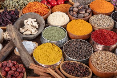 Kase içinde pişirmek için çeşitli otlar ve baharatlar içeren renkli bir arka plan. Baharat ve bitkilerle kusursuz bir doku..