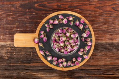 Kurutulmuş gül düşmesi. Kurutulmuş gül tomurcukları çayı. Gül çayı, çiçekler ve kurutulmuş yapraklar. Kuru pembe gül tomurcukları.