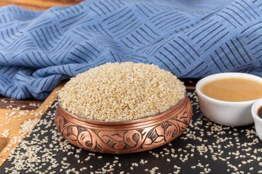 Lezzetli susam ezmesi ve tohumlar. Bir sürü beyaz susam tohumuna yakın çekim. Beyaz susam tohumu yığını.